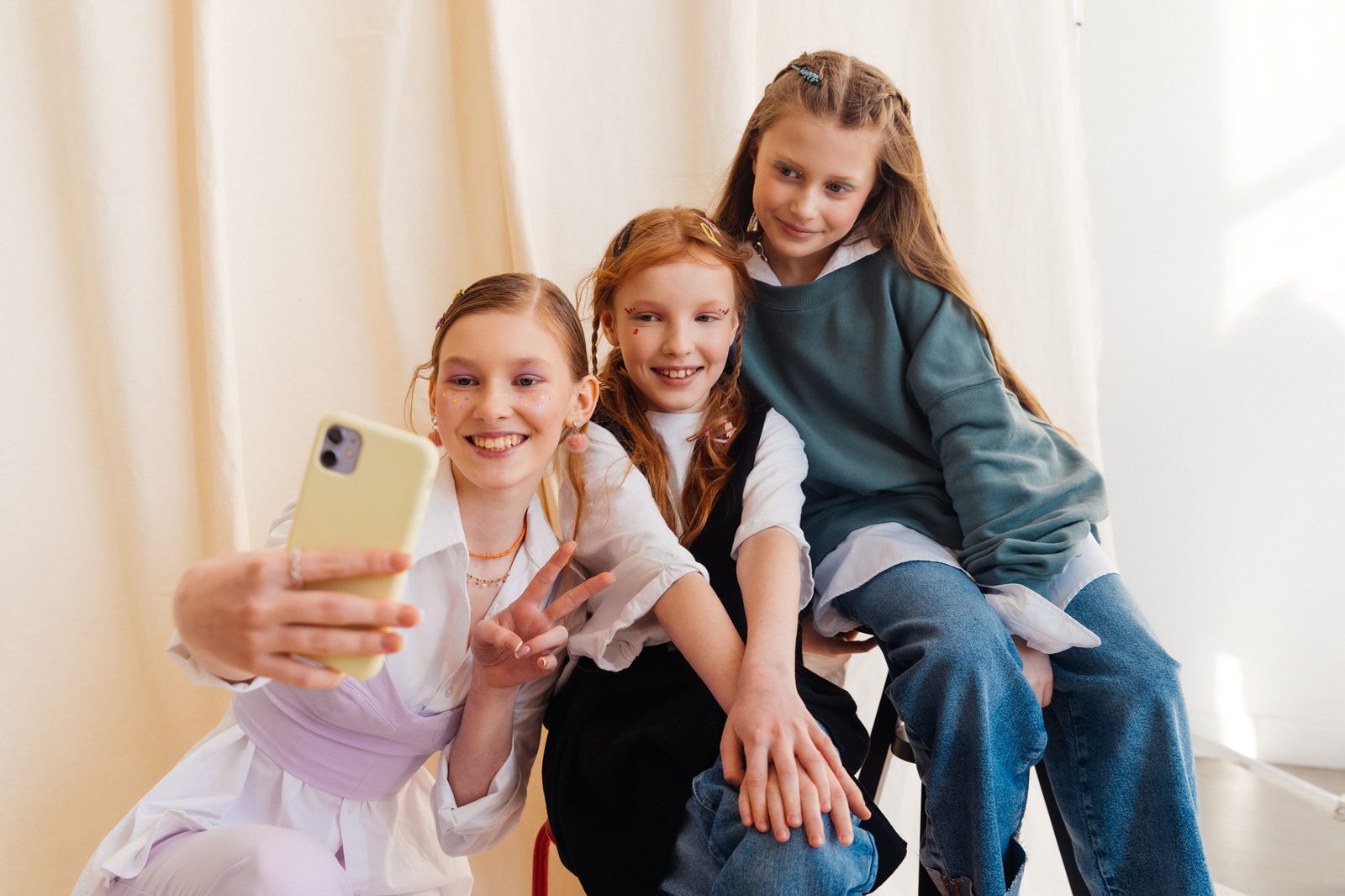 Kolme teini-ikäistä tyttöä ottaa yhdessä selfietä
